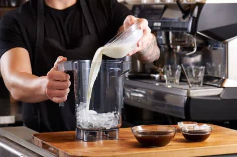 Vitamix Commercial Why Ingredients Won't Blend? - FoodSERV. A person prepping a blender filled with ice by adding in the ingredients | FoodServ